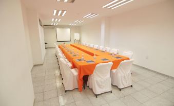 a conference room with orange tablecloths and white chairs , set up for a meeting or presentation at Hotel St. George