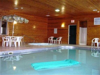 an indoor pool with a blue float in the water , surrounded by wooden walls and chairs at Country Inn & Suites by Radisson, Watertown, SD