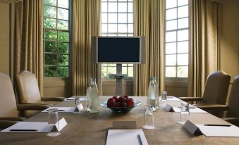 a conference room set up for a meeting , with a table and chairs arranged in a semicircle around the room at Brandshatch Place & Spa