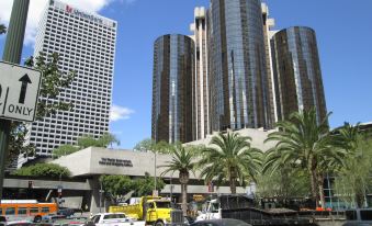 a busy city street with tall buildings , cars , and trucks parked on the side of the road at The Westin Bonaventure Hotel & Suites, Los Angeles