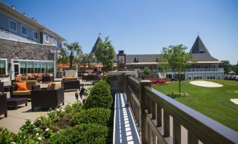 a modern building with a green roof , surrounded by trees and flowers , under a clear blue sky at Courtyard Philadelphia Springfield