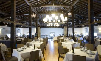 a large , well - lit dining room with multiple tables and chairs arranged for a group of people at Parador de Argomaniz