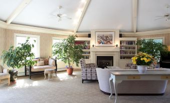 a spacious living room with a fireplace , bookshelves , and various furniture , including a couch and chairs at Southampton Inn