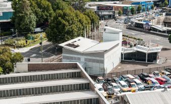 a bird 's eye view of a parking lot with cars and buildings in the background at ValueSuites Green Square