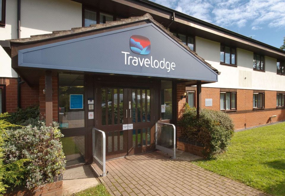a travelodge hotel entrance with a large sign above the door , welcoming guests to their stay at Travelodge St. Clears Carmarthen
