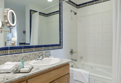 a bathroom with a sink , toilet , and bathtub , along with a mirror above the sink at Wyndham Reef Resort Grand Cayman