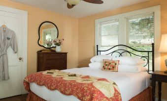a cozy bedroom with a large bed , a mirror on the wall , and a fan at BlissWood B&B Ranch