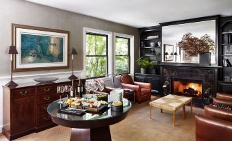 a cozy living room with a round table , two couches , and a fireplace , creating a warm and inviting atmosphere at Gaige House