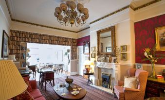 a large , well - lit living room with a fireplace and multiple couches , creating a cozy atmosphere at The Ascott