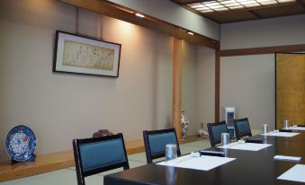 a conference room with a table , chairs , and papers set up for a meeting or presentation at Osakaya Ryokan