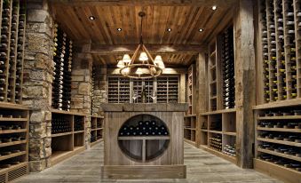 a wine cellar with wooden walls and ceiling , containing numerous bottles of wine on shelves , as well as a small cave - like structure at Sportsman's Inn Resort & Marina