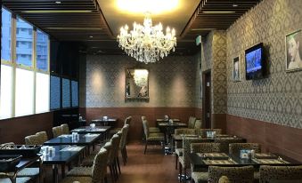 There is a restaurant with tables, chairs, and chandeliers, located in front of the hotel at Best Western Hotel Causeway Bay