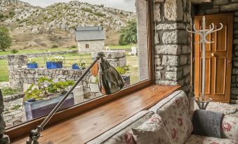 a room with a large window that offers a view of a house and a field at El Lucero