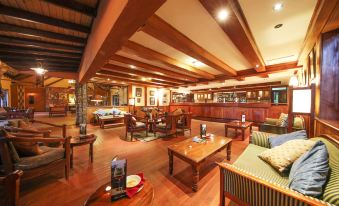 a large wooden room with multiple couches , chairs , and tables , creating a cozy atmosphere for socializing and gatherings at Muthu Keekorok Lodge, Maasai Mara, Narok