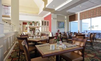 a large dining room with multiple tables and chairs arranged for a group of people to enjoy a meal together at Hilton Garden Inn Kennett Square