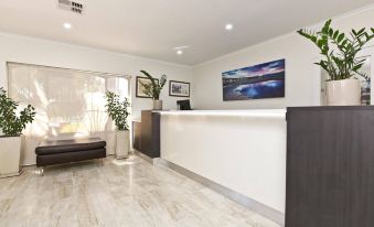 a modern office reception area with white walls , wooden floors , and a large window offering views of the ocean at Morphettville Motor Inn