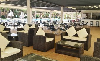 a large outdoor dining area with several couches and chairs arranged for guests to enjoy at Bimbolla Apartaments