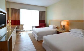 The empty space at the far end of the room features two beds and a large window at Four Points by Sheraton Kuching