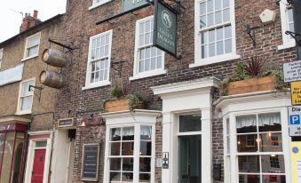 "the exterior of a brick building with white trim and a sign that reads "" the bar & grill ""." at The Green Dragon at Bedale