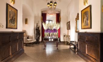 a large , elegant foyer with a grand piano in the center , surrounded by couches and chairs at Kilkea Castle