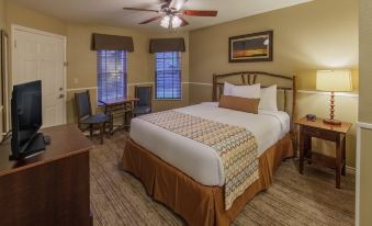 a large bed with a wooden headboard and white linens is in a hotel room at Holiday Inn Club Vacations Villages Resort Lake Palestine