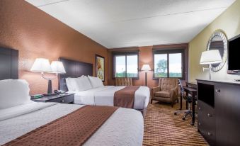 a hotel room with two beds , a desk , and chairs , along with a window and a couch at Holiday Inn Manitowoc