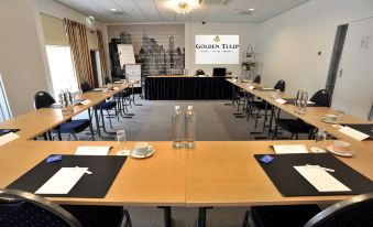 a conference room set up for a meeting , with chairs arranged in rows and a table in the center at Fletcher Hotel-Restaurant Zevenbergen-Moerdijk