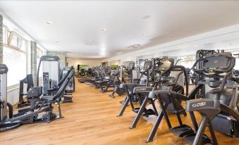 a large , well - equipped gym with various exercise equipment , such as treadmills , weight machines , and benches at Hotel Heimatlodge