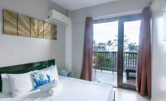 a bedroom with a large bed and sliding glass doors leading to a balcony overlooking the ocean at Reef Beach Resort