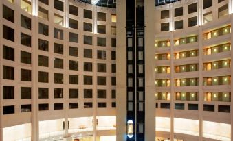 a large hotel lobby with a tall atrium , where people are standing and walking around at Radisson Blu New Delhi Dwarka