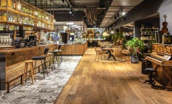 a modern coffee shop with wooden floors and chairs , as well as a bar area at Novotel Avignon Nord