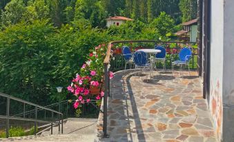 a stone terrace with a flower bed , outdoor furniture , and a view of a garden at Gemma