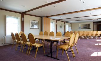 a large conference room with multiple chairs arranged in rows , creating an inviting atmosphere for meetings and events at The Mill Hotel