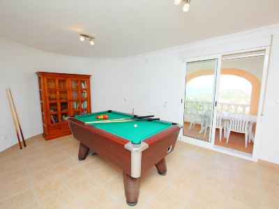 a pool table with a cue stick and balls on it in a room with white walls at Joli Joli Photo