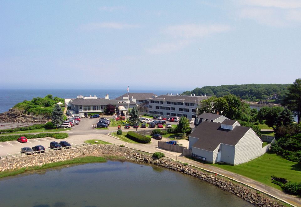 aerial view of a large building surrounded by water , with a dock extending into the ocean at Stage Neck Inn