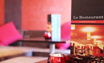 "a dining table with a wine glass and a booklet titled "" le resta "" on it" at Best Western the Hotel Versailles