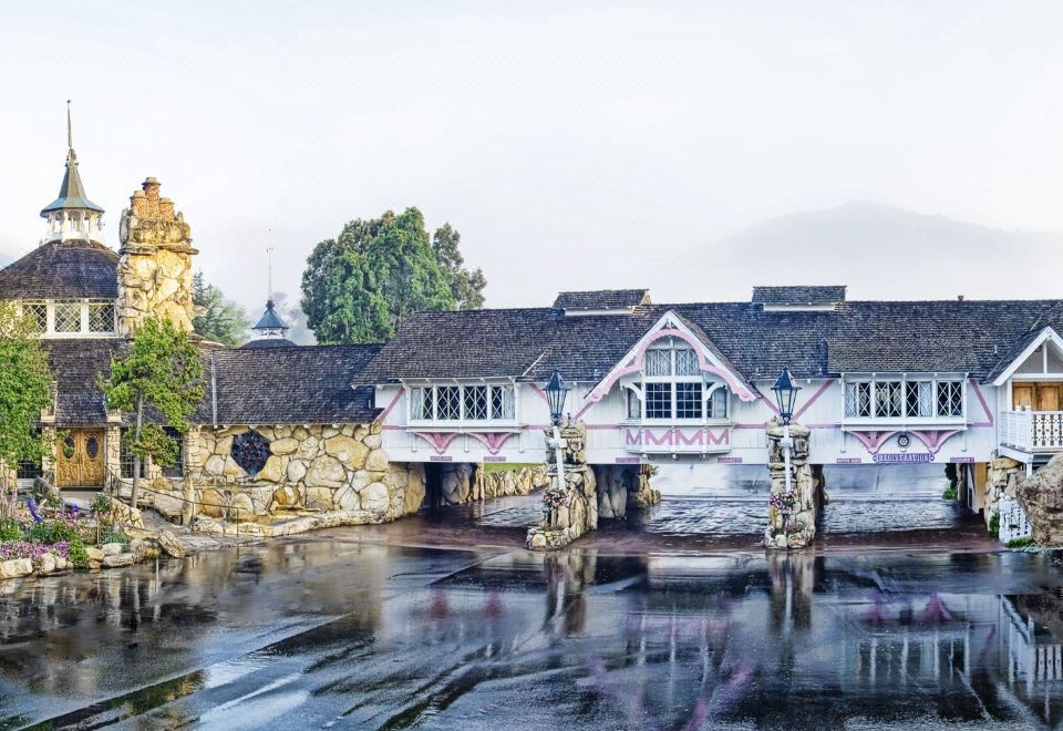 a picturesque scene of a small town with a bridge over a body of water , surrounded by houses and trees at Madonna Inn