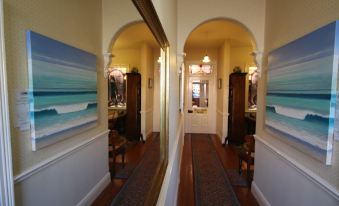 a hallway with two large mirrors hanging on the wall , one on the left and one on the right at Seaview House