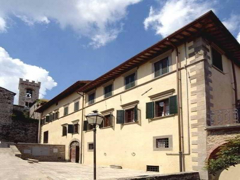 a traditional european - style building with white walls and green shutters , situated in a sunny environment under a clear blue sky at Palazzo Leopoldo Dimora Storica & Spa