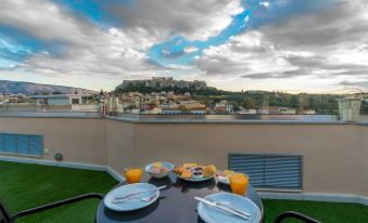 a table with plates and silverware is set up on a balcony overlooking a cityscape at Lotus Inn