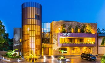 a modern building with a curved facade and large windows , surrounded by trees and lit up at night at Peduase Valley Resort