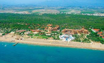 a large resort with multiple buildings , pools , and trees is shown from an aerial view at Asteria Family Resort Belek