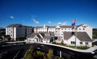 an aerial view of a large , well - maintained building with multiple flags flying in front of it at Residence Inn Auburn