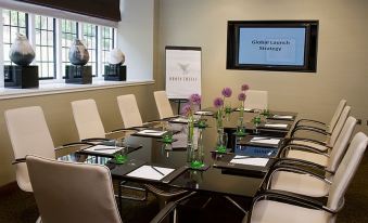 a conference room set up for a meeting , with several chairs arranged in a semicircle around a table at Bovey Castle