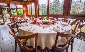 a dining room with a round table surrounded by chairs , all set for a meal at Hotel Golfer