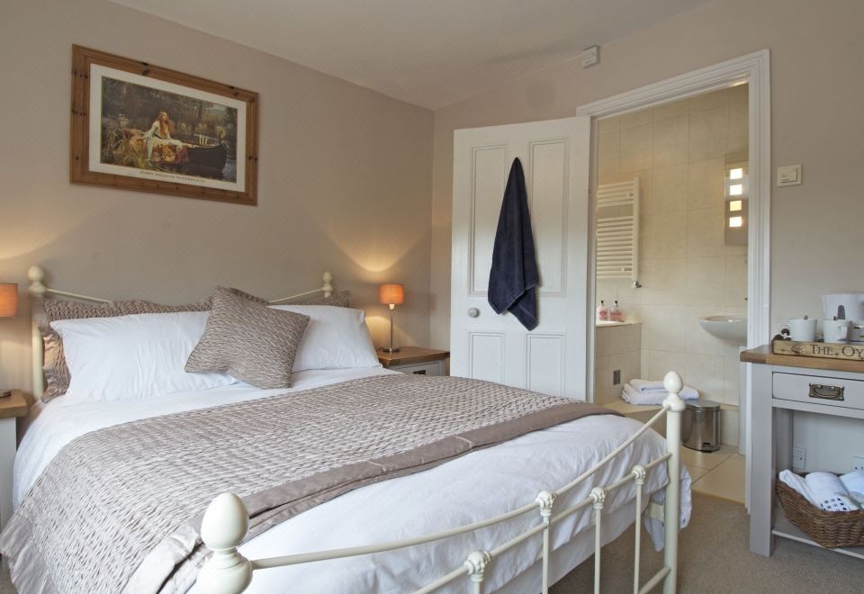 a well - decorated bedroom with a white bed , a blue towel on the door , and a mirror above the bed at Marsh House Farm