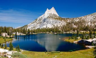 a mountainous landscape with a large body of water , possibly a lake , in the foreground at Inside Yosemite Lower Cascades