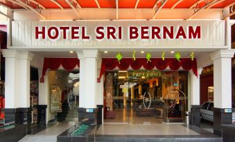 a hotel entrance with a large sign above the door and a red canopy above at Hotel Sri Bernam