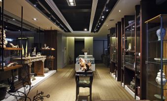 a room with a wooden table and chairs in the center , surrounded by glass shelves filled with various items at Micasa Hotel