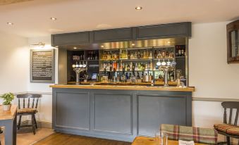 a bar with a long counter and various bottles and glasses on the counter , creating an inviting atmosphere for patrons at The Rodney